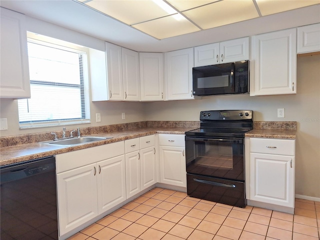 kitchen with light tile patterned floors, sink, white cabinetry, and black appliances