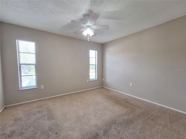 unfurnished room with ceiling fan, carpet floors, and a textured ceiling