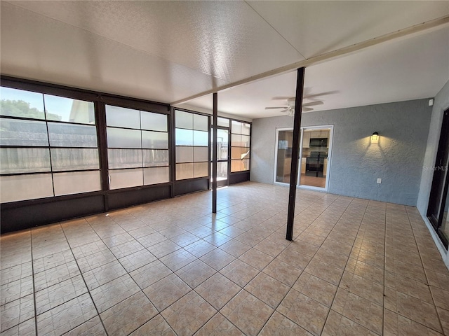 unfurnished sunroom with ceiling fan and a healthy amount of sunlight