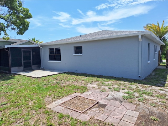 back of property featuring a sunroom, a yard, and a patio