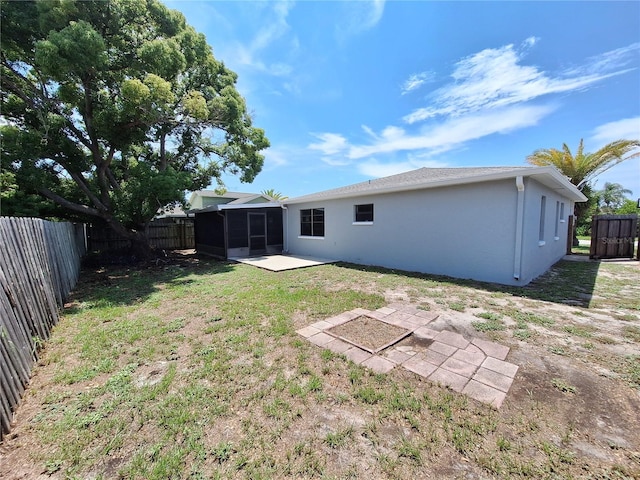 rear view of house featuring a yard and a patio area