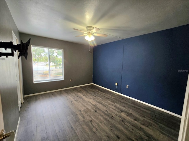 spare room featuring a textured ceiling, ceiling fan, and dark wood-type flooring