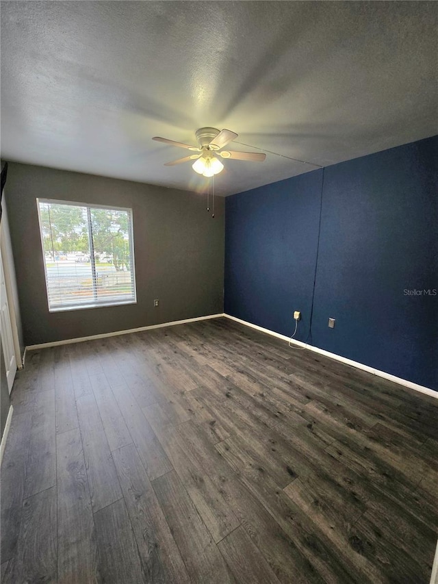 unfurnished room featuring a textured ceiling, ceiling fan, and dark wood-type flooring