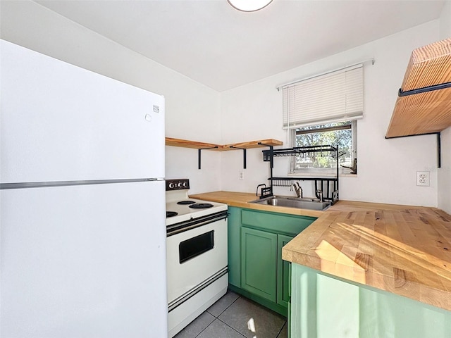 kitchen with sink, wood counters, green cabinets, white appliances, and light tile patterned flooring