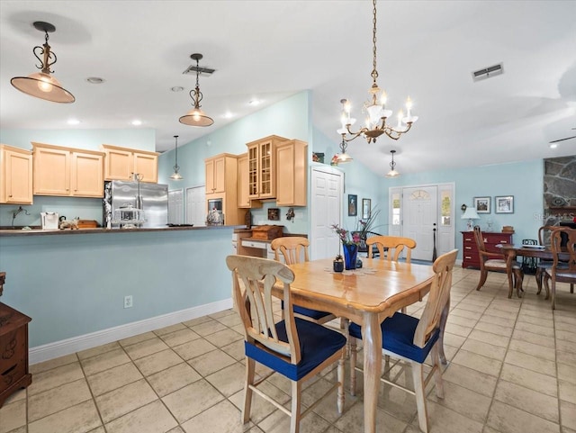 tiled dining area featuring vaulted ceiling and an inviting chandelier