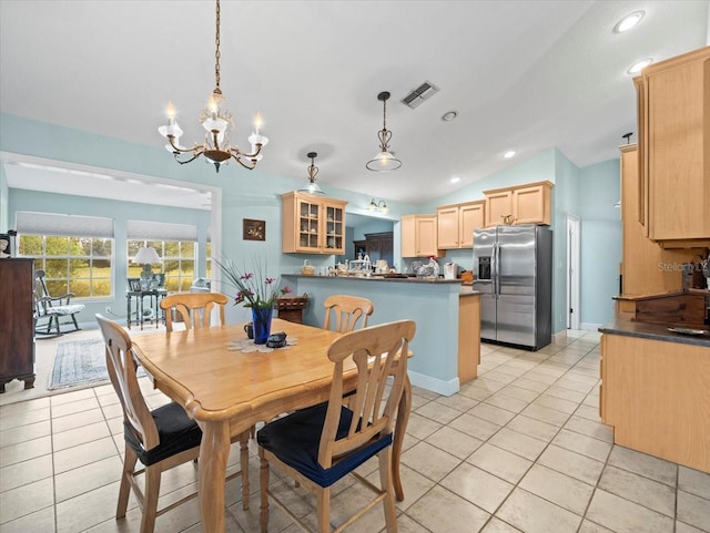 tiled dining area featuring vaulted ceiling and a notable chandelier