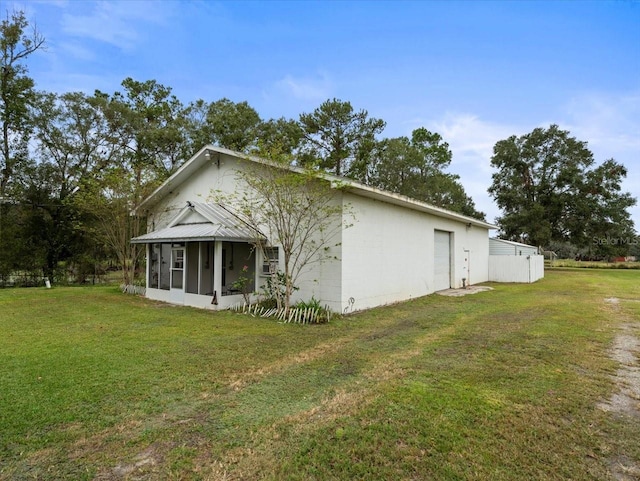 view of home's exterior with a lawn and a sunroom