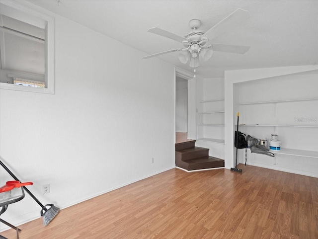 unfurnished living room featuring built in features, light hardwood / wood-style flooring, and ceiling fan