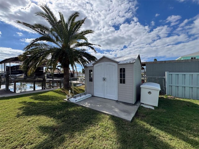 view of outdoor structure featuring a lawn and a water view