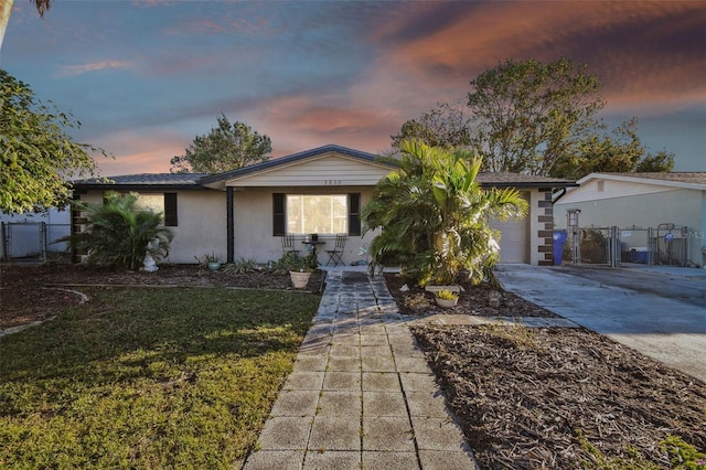 ranch-style house featuring a garage and a yard