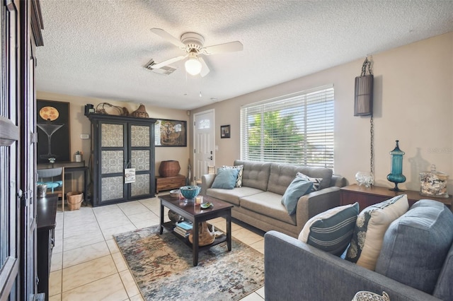 tiled living room featuring ceiling fan and a textured ceiling