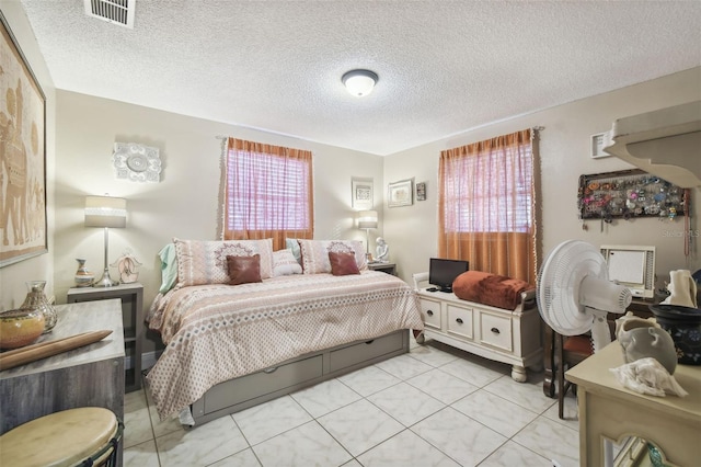 bedroom with a textured ceiling and multiple windows