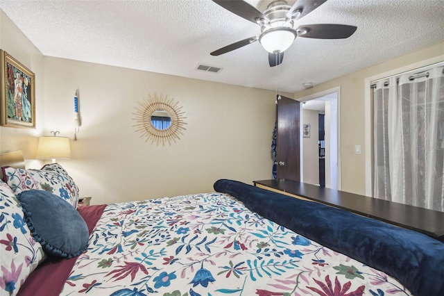 bedroom with ceiling fan and a textured ceiling