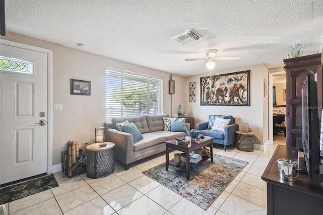 tiled living room with ceiling fan and a textured ceiling