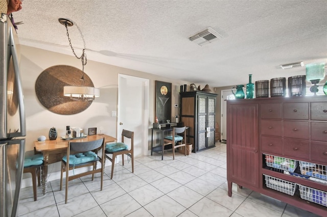 tiled dining area with a textured ceiling