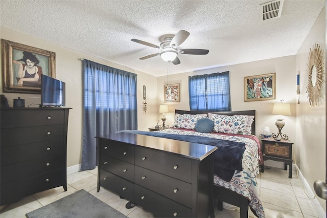 tiled bedroom featuring ceiling fan, a textured ceiling, and multiple windows