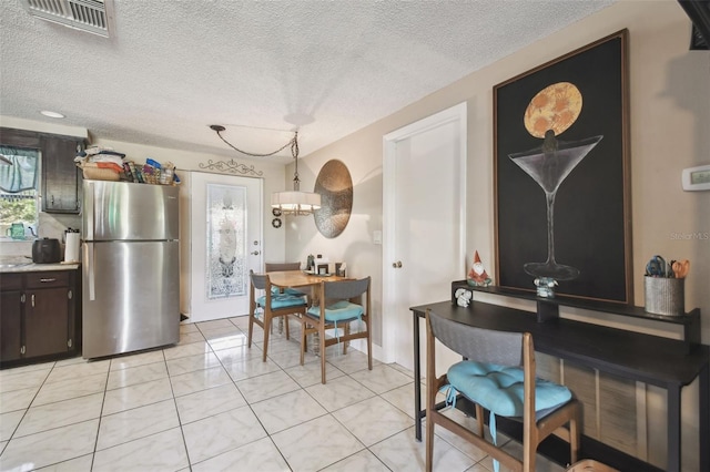 dining space featuring light tile patterned floors and a textured ceiling