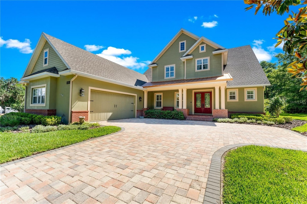 craftsman-style house featuring covered porch, french doors, and a garage