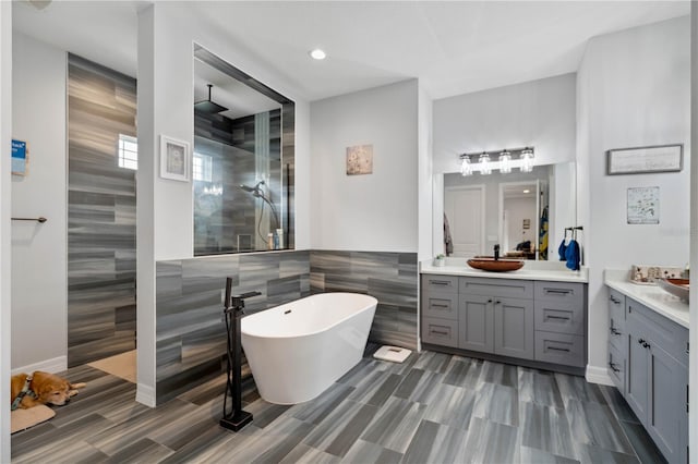 bathroom with vanity, separate shower and tub, and tile walls