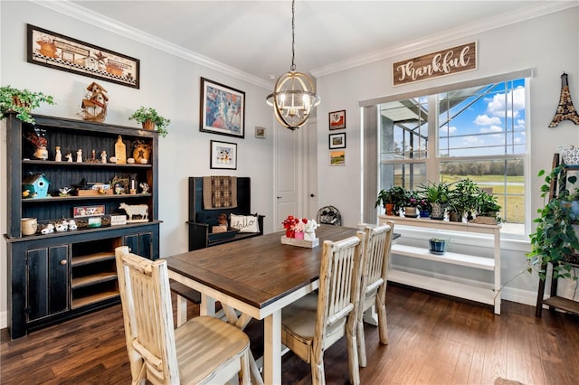 dining area featuring dark hardwood / wood-style flooring, crown molding, and an inviting chandelier