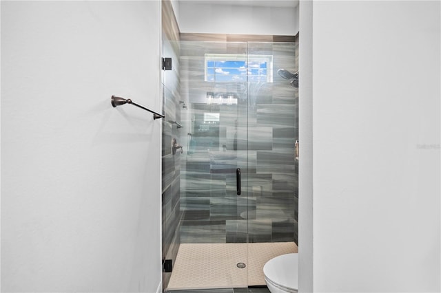 bathroom with toilet and a shower with shower door