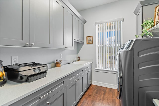 washroom featuring cabinets, sink, dark hardwood / wood-style floors, and washing machine and clothes dryer