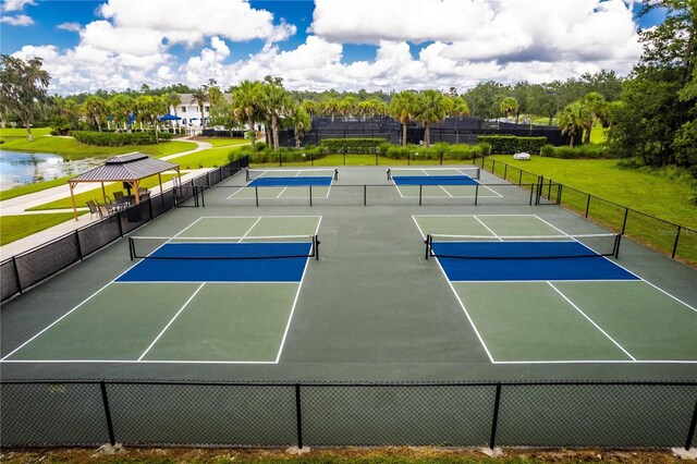 view of tennis court with basketball court, a lawn, and a water view