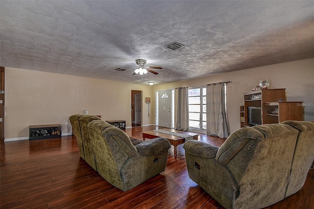 living room featuring a textured ceiling, ceiling fan, and dark hardwood / wood-style floors