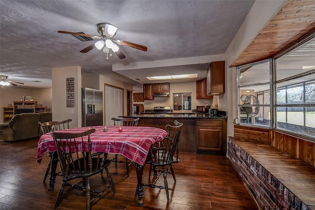 dining area with a textured ceiling, ceiling fan, and dark hardwood / wood-style floors