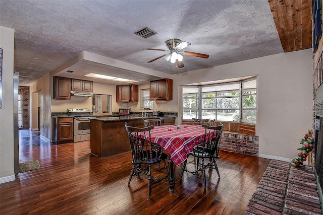 dining space featuring a textured ceiling, ceiling fan, and dark wood-type flooring