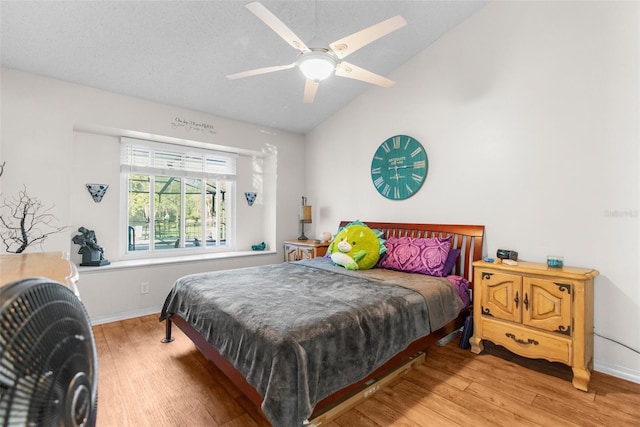 bedroom featuring baseboards, wood finished floors, a ceiling fan, and vaulted ceiling