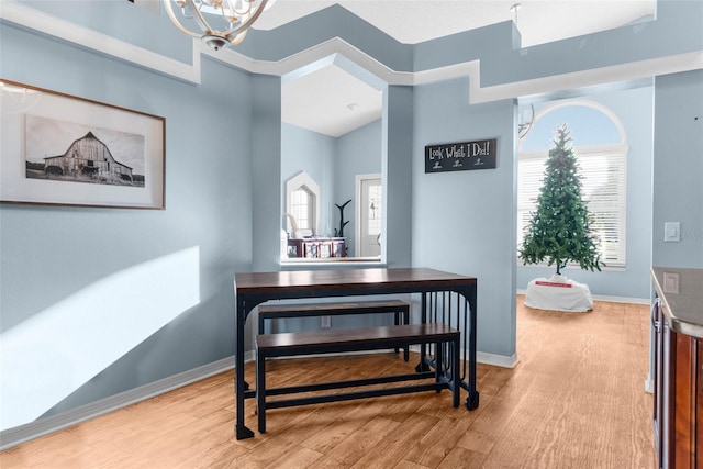 dining area with a wealth of natural light, a notable chandelier, and light wood-style flooring