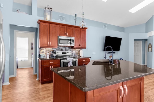 kitchen with a sink, light wood-style flooring, visible vents, and stainless steel appliances