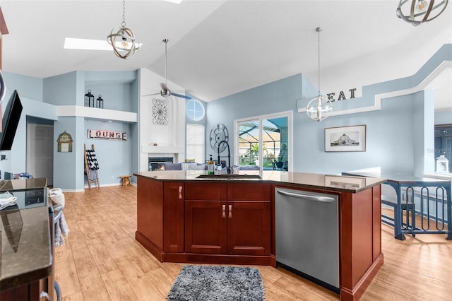 kitchen featuring a sink, stainless steel dishwasher, open floor plan, a fireplace, and ceiling fan