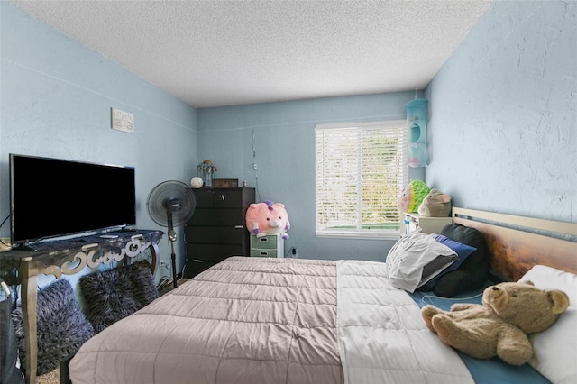 bedroom featuring a textured wall and a textured ceiling