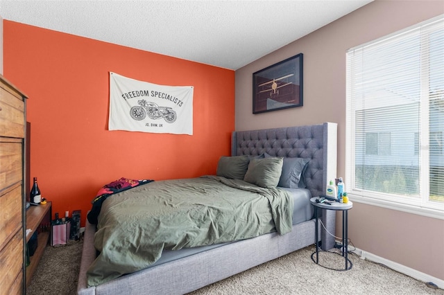 carpeted bedroom with a textured ceiling and baseboards