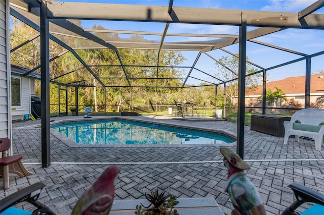 outdoor pool featuring glass enclosure and a patio area