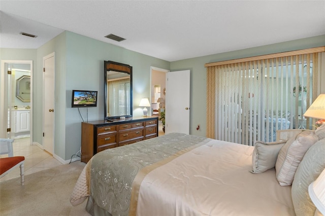 bedroom featuring connected bathroom and light colored carpet