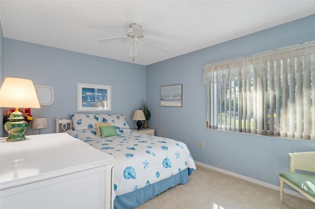 carpeted bedroom featuring ceiling fan and a textured ceiling