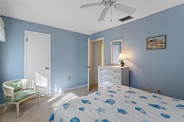 carpeted bedroom featuring ceiling fan and a textured ceiling