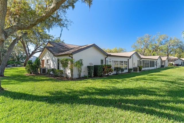 view of side of home featuring a lawn and central air condition unit