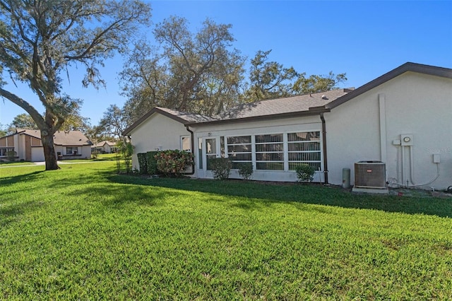 back of house featuring a yard and central AC unit