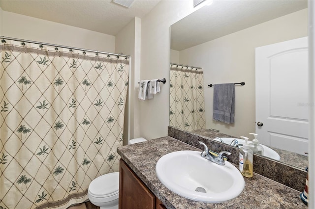 bathroom with walk in shower, vanity, a textured ceiling, and toilet