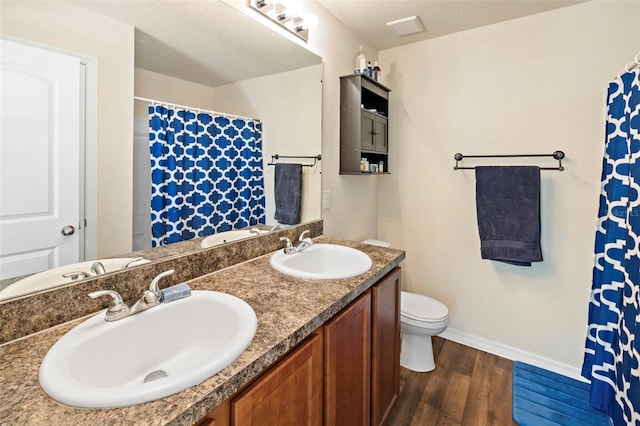 bathroom with vanity, wood-type flooring, and toilet