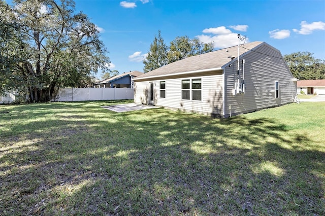 back of house with a patio area and a lawn