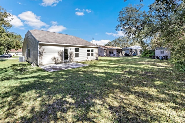 rear view of property with a lawn, cooling unit, and a patio