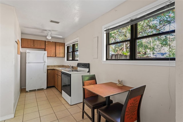 kitchen featuring light tile patterned floors, white appliances, ceiling fan, and sink