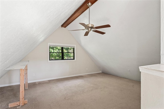 additional living space with ceiling fan, carpet floors, and lofted ceiling with beams