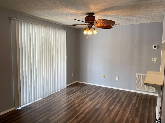 spare room featuring a textured ceiling, ceiling fan, and dark wood-type flooring