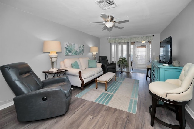 living room with ceiling fan and dark wood-type flooring